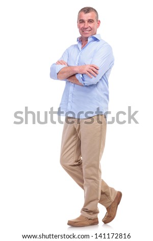 full length picture of a casual senior man standing with arms folded and looking at the camera. isolated on white background