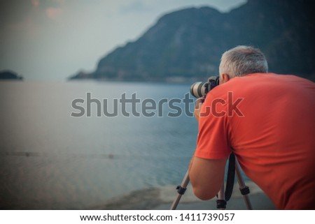 the photographer takes a photo on the sea in the mountains