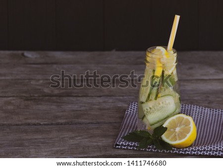 Detox concept. Cucumber and lemon healthy diet cocktail on wooden background. Free copy space.