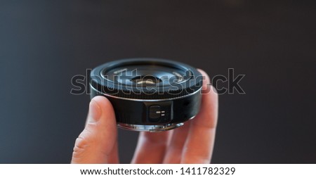 Small black pancake photographic lens.