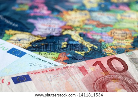 Euro banknotes on the map of Europe, selective focus. Concept for european economy, eurozone countries Royalty-Free Stock Photo #1411811534