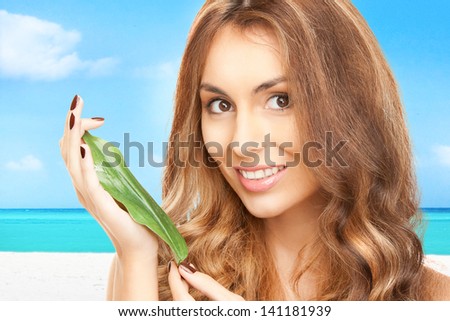 picture of woman with green leaf over tropical beach background