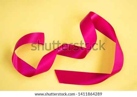 Red ribbon isolated on a yellow background