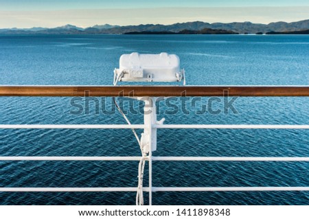 White metal exterior light fixture on railing of cruise ship, Alaska Inside Passage route.