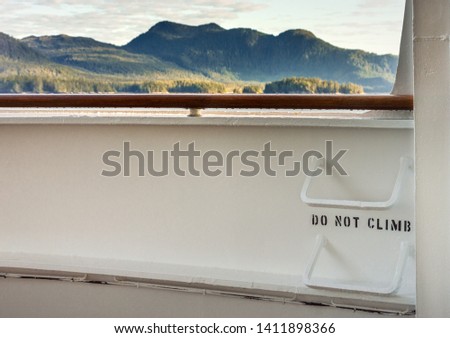 Metal ladder rungs on cruise ship deck with view of mountain scenery in background ner Ketchikan, Alaska.