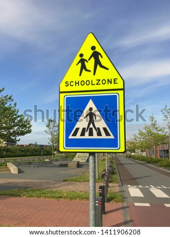 Dutch traffic road sign warning for a school zone and crosswalk.