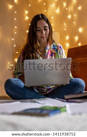 Woman working on her laptop on the bed.