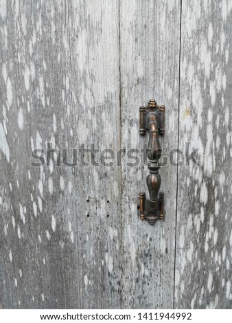 The old door handles that are dotted with patterns of old wood of wooden doors