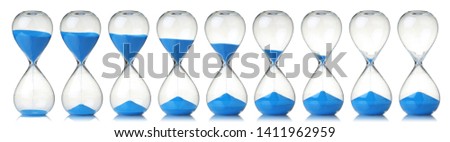 Collection of hourglasses with blue sand showing the passage of time Royalty-Free Stock Photo #1411962959