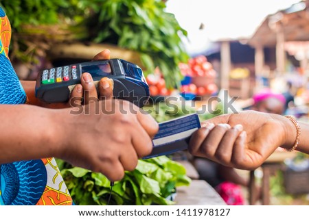 African market woman accepting credit card for payment from a customer Royalty-Free Stock Photo #1411978127