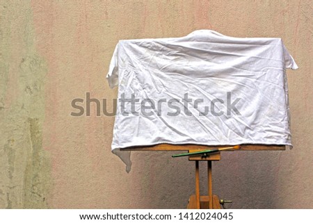 Easel painting The cement walls of the old background.White cloth covered works.