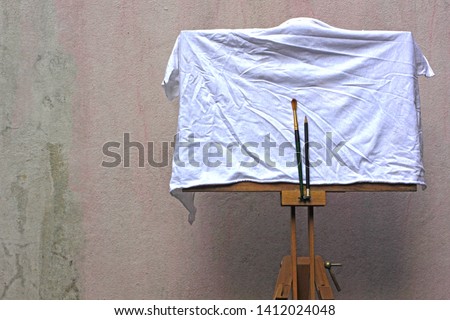 Easel painting The cement walls of the old background.White cloth covered works.