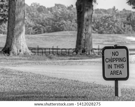 A Golf Course Sign That Says "No Chipping in This Area"