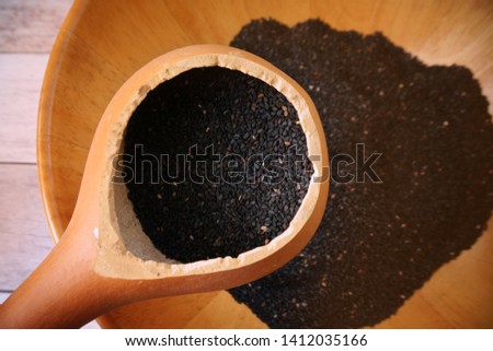 Black Sesame in wood bowl and dry bottle gourd spoon.On wood table
