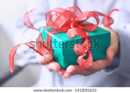 Green gift box in hand.                     