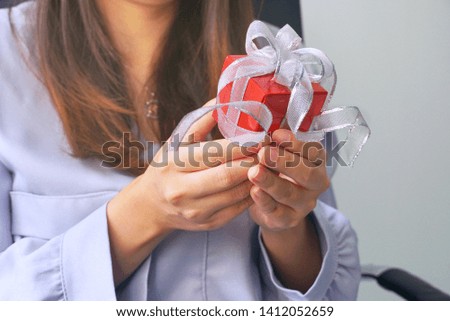 Women receive red gift box.
