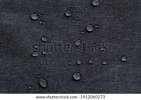 Waterproof droplets on fabric. Black Canvas Polyester texture synthetical for background. Black polyester textile backdrop for interior art design or add text message.