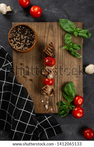 Grilled meat skewers on wooden board with vegetable salad– stock image