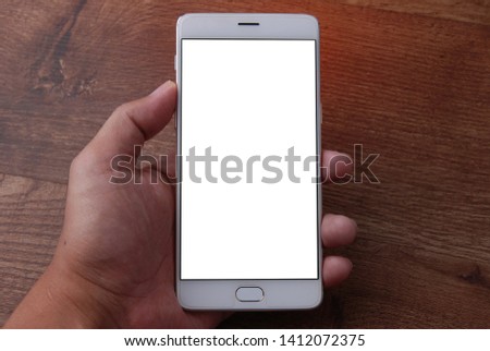 Close up of woman hand holding smart phone on wooden background