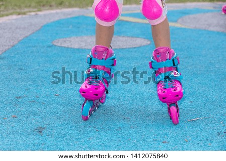 Little girl playing with roller skates at outdoor playground