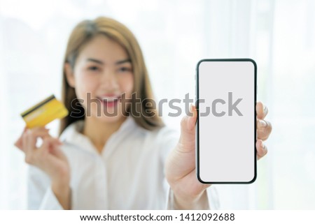 Concepts about notification after using a credit card. Women who are carrying credit cards and smartphones, A smartphone that is a white area for text or advertising. 