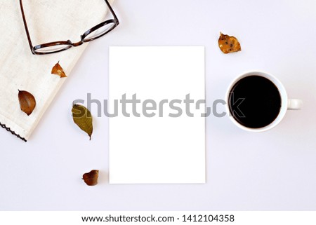 Blank white note card on desk with coffee and eyeglasses.