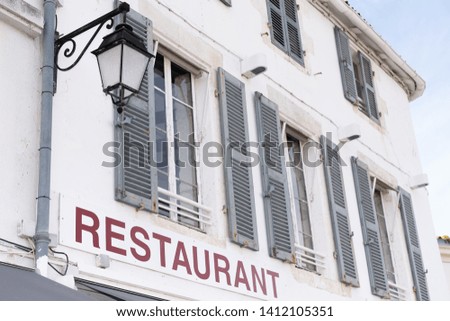 Old stone restaurant facade in isle Ile de Re in france with grey green shutter