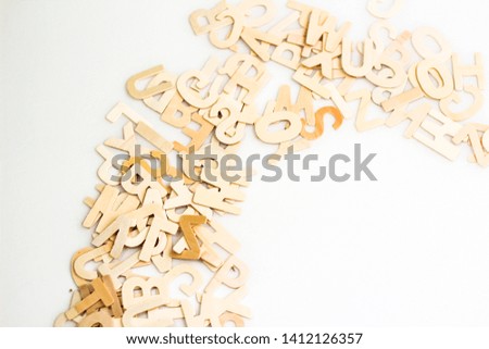 Wooden alphabets lay on white background.  Brown color alphabets toys.