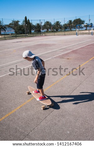 Young boy playing with a skate board wearing a cup