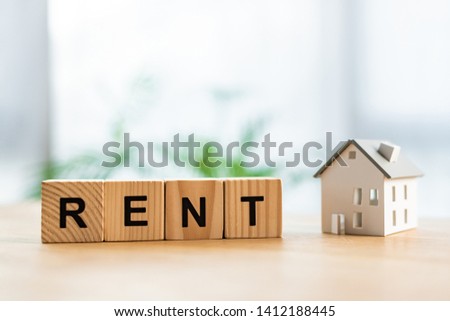 cardboard house near wooden cubes with rent lettering on table 