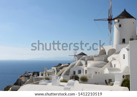 Santorini  oia fira caldera classic view in the middle of the sunny day. Traditional greek white houses and windmills.