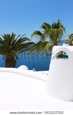 Tropical vacations. White roof with a chimney. Palm trees on the back. Mediterranean village with white stone houses. Traditional greek architecture.