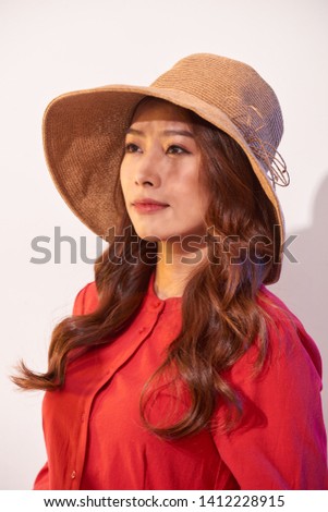 Happy thinking young woman looking up in straw hat on white background with empty copy space