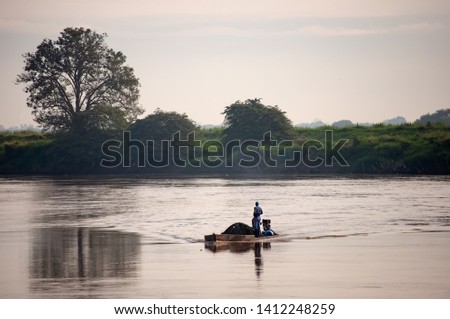 Fisherman at sunrise in his canoe on a river in Colombia