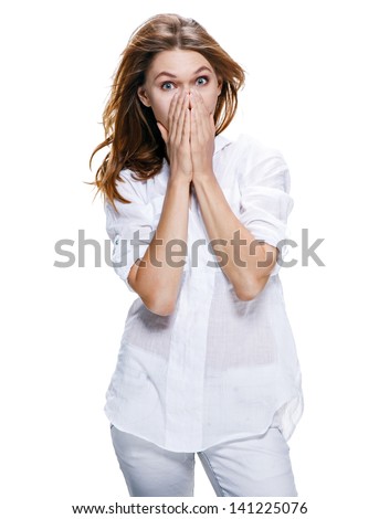Young surprised beautiful woman / surprised girl of european appearance in a white suit puts her hands over her mouth - isolated on white background
