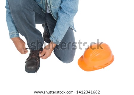 Working men are tying shoes He placed a helmet on a white background. clipping path