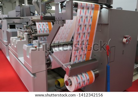 Flexographic printing machine working on labels Royalty-Free Stock Photo #1412342156