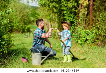 small boy child help father in farming. Eco farm. father and son in cowboy hat on ranch. use watering can and pot. Garden equipment. happy earth day. Family tree nursering. childrens day.