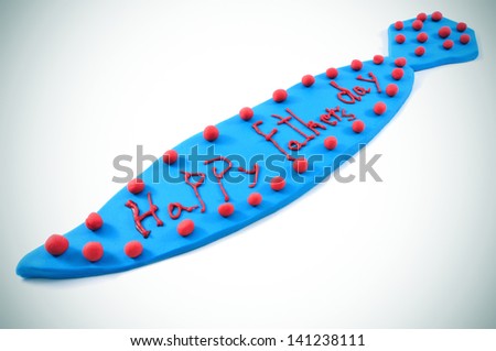 a tie made with blue modeling clay with the sentence happy fathers day written in red, on a white background