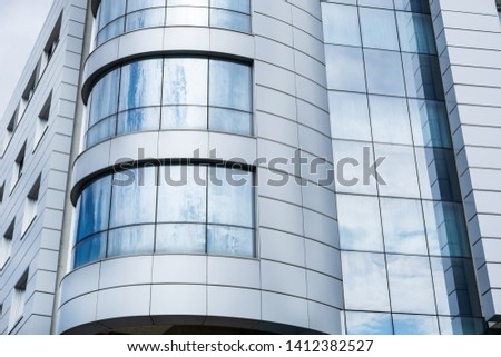 Modern building clean facade and windows with cloudy sky reflection. Modern architecture and exterior concept. Close up, selective focus