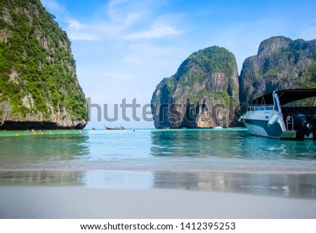View from Maya Bay Beach with speedboat in foreground, popular tourist attraction in the Phi Phi Islands, Thailand.