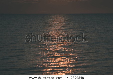 red saturated colors in sunset over the baltic sea with calm water and sun reflections in Estonia - vintage old film look