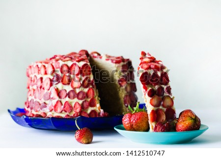 cake with custard and strawberry slices on a blue plate