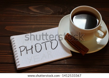 Photo inscription and word in a notebook near a cup of coffee