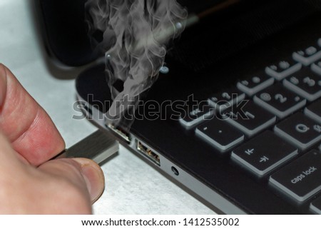 The man pulled out a flash drive from the port and the port began to smoke. Concept
