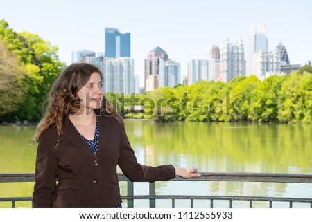Atlanta, Georgia cityscape view in Piedmont Park green trees urban city skyscrapers with happy young business woman girl