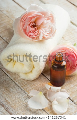 Essential aroma oil with rose on wooden background. Selective focus.