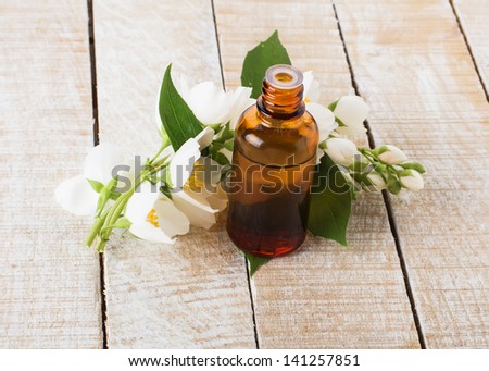 Essential aroma oil with jasmine on wooden background. Selective focus.
