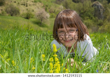 Cute little girl lying in the grass and laughing