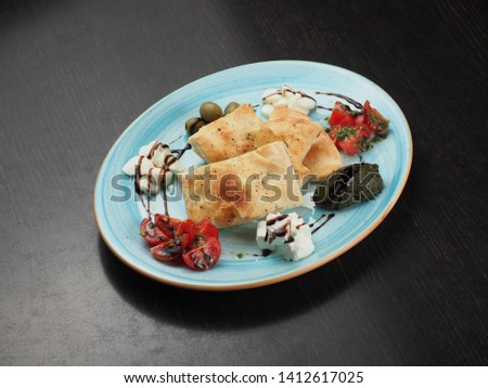 Pita bread served with tomatoes, olives and cheese in a plate